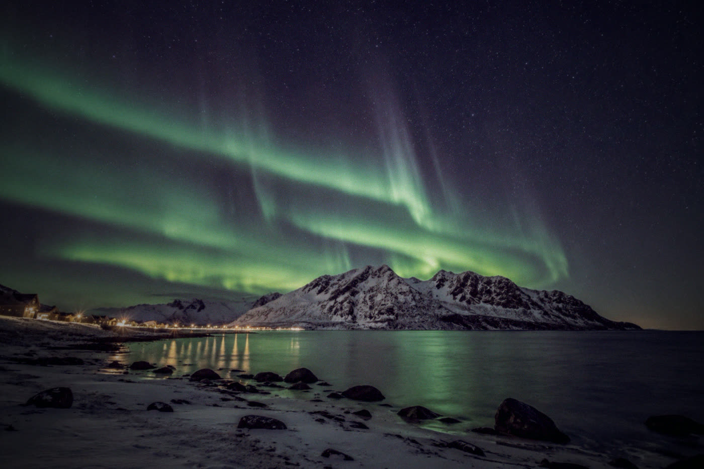 Aurora bands reflected in the sea at a Senja beach
