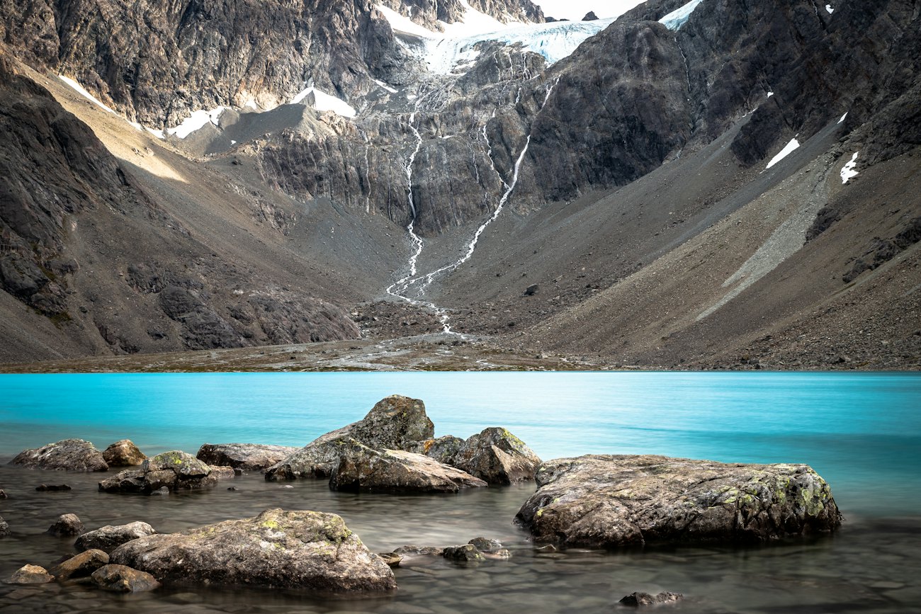 The turquoise glacial lake Blåisvatnet beneath the peaks of the Lyngen Alps