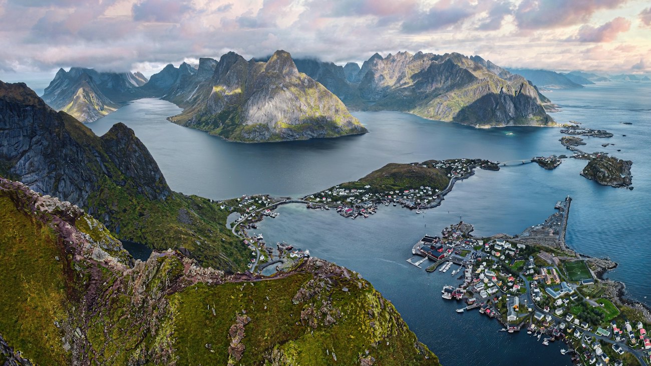 The village of Reine spread across small islands among fjords and peaks, seen from Reinebringen