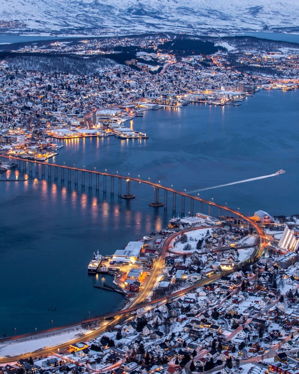 Aerial view of the Tromsø Bridge and the city lit up on a winter night